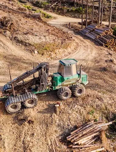 A modern forest machine in a felled forest from above.
