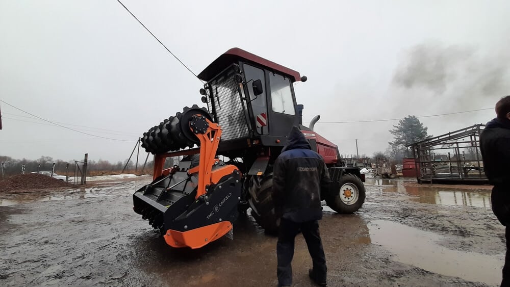 Forestry mulcher with tractor on muddy ground at farm on.